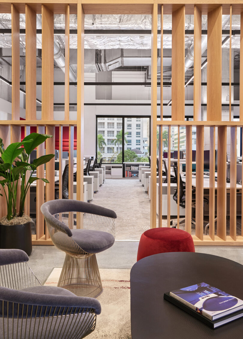 seating area in front of a wooden partition that sections of rows of workstations