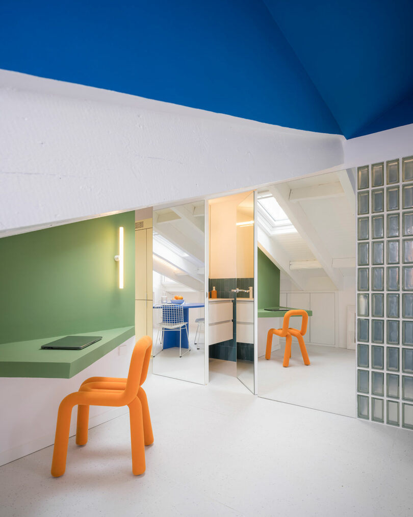 Modern attic conversion featuring a green and white color scheme with glass block details and colorful furniture.