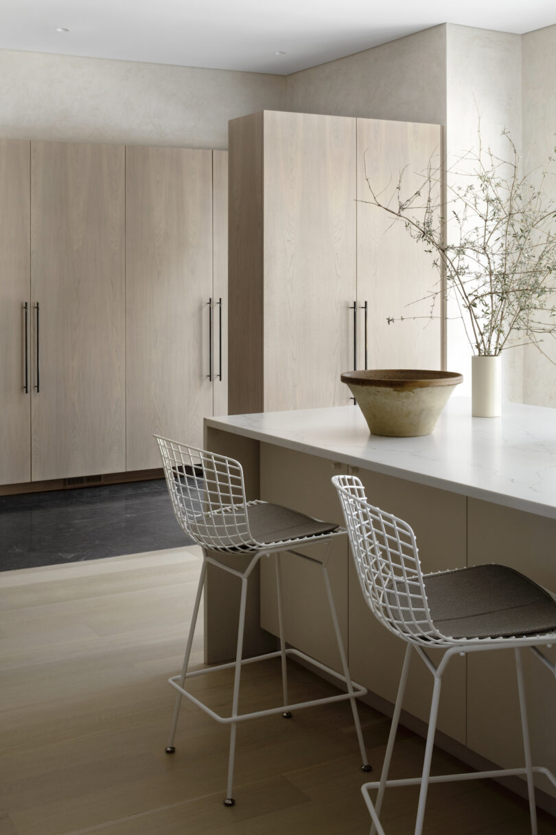 two chairs next to kitchen island next to storage cabinets